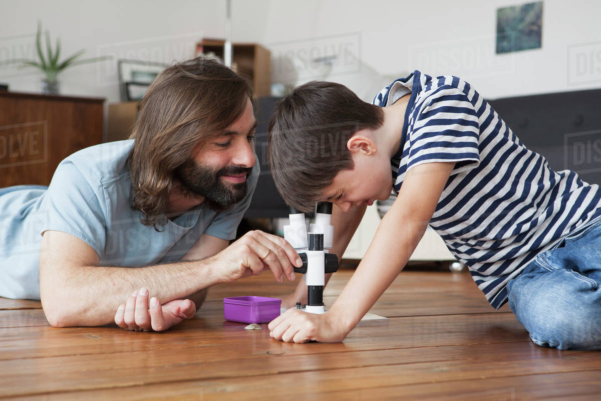 Father And Son Using Microscope On Hardwood Floor Stock Photo Father And Son Using Microscope On Hardwood Floor