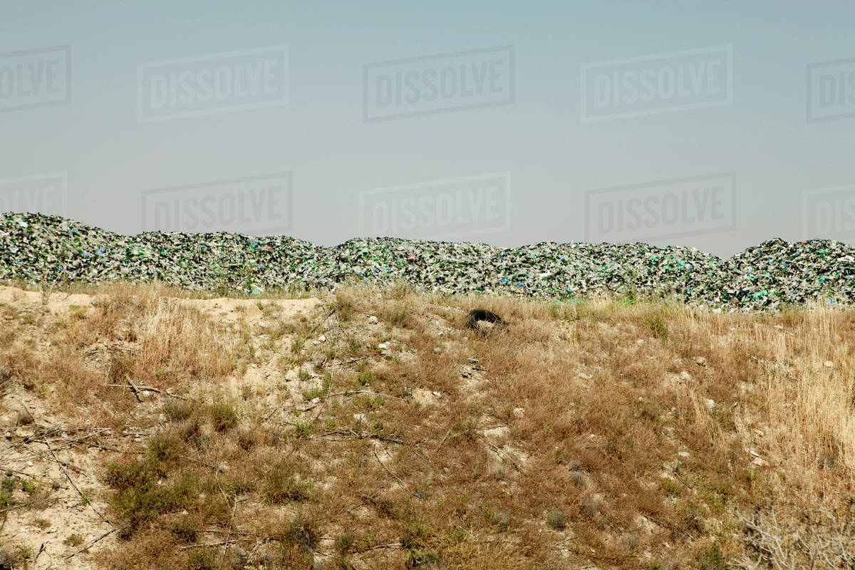 Garbage heap on field against clear sky Stock Photo Dissolve