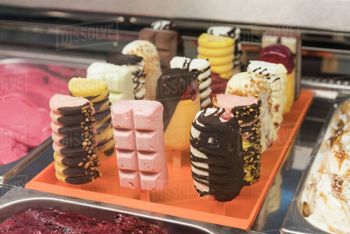 Various ice cream popsicles on display at store Stock Photo Dissolve