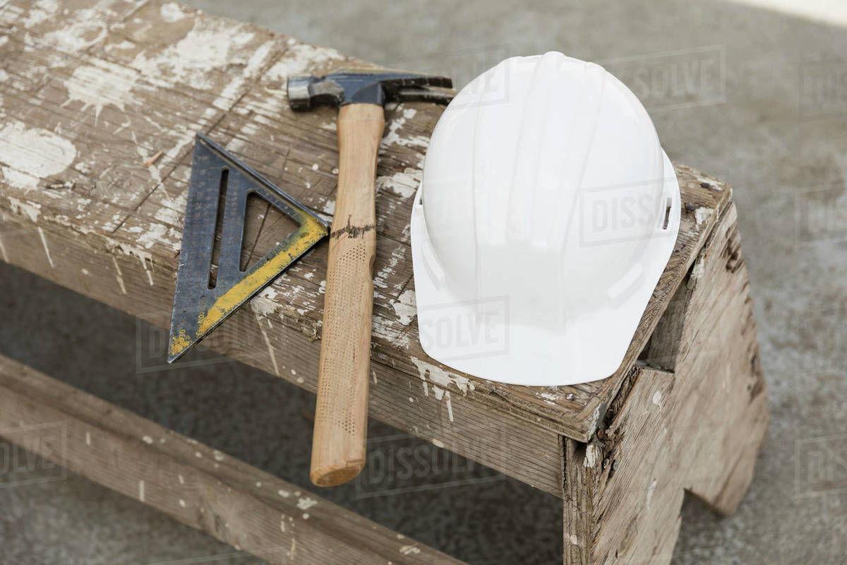 Hardhat, hammer and ruler on bench Stock Photo Dissolve