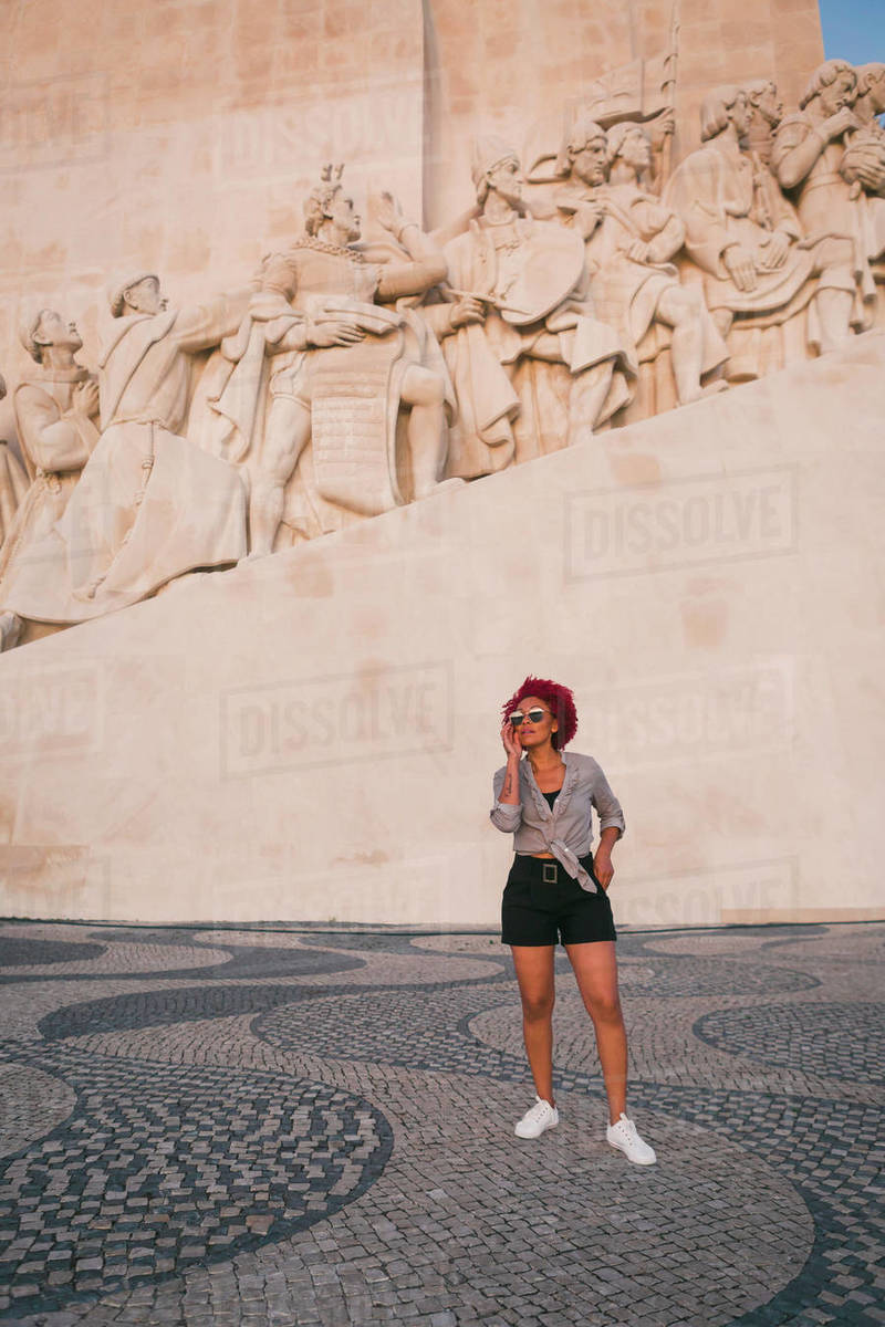 Stylish woman in sunglasses below Monument to the Discoveries, Lisbon, Portugal Royalty-free stock photo