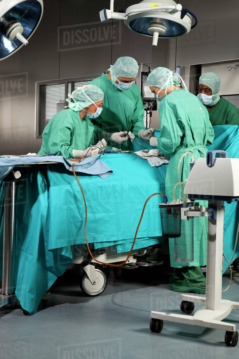 Doctors and nurses operating on a patient in a operating room Stock